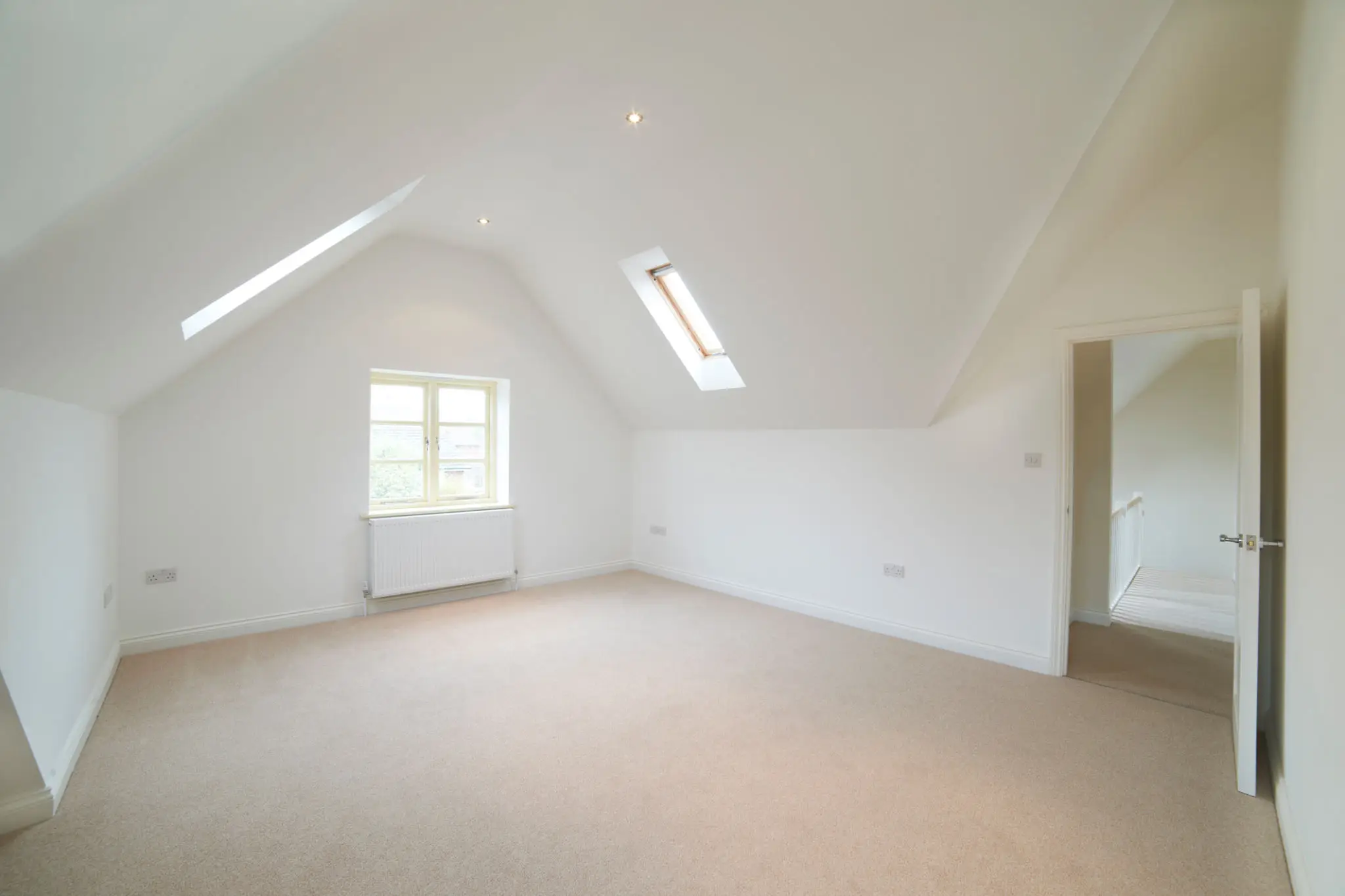 Empty attic room with skylights